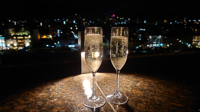 きらめく夜景を背景にしたシャンパングラス2杯