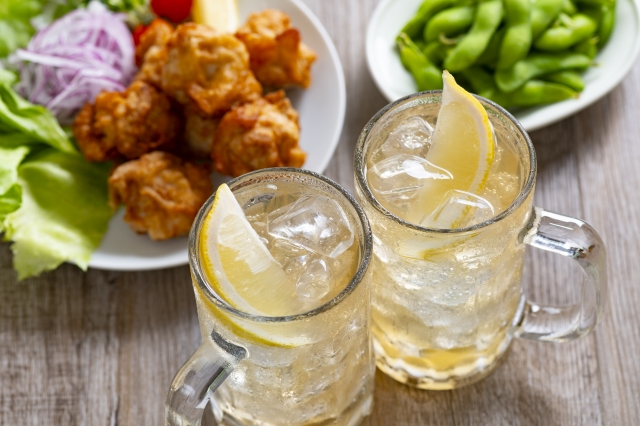 居酒屋のハイボールジョッキと唐揚げ・枝豆のおつまみ