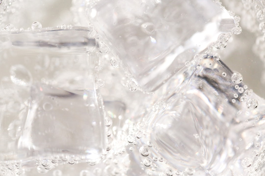 氷を入れたタンブラーに注がれた透明な炭酸の飲み物のクローズアップ